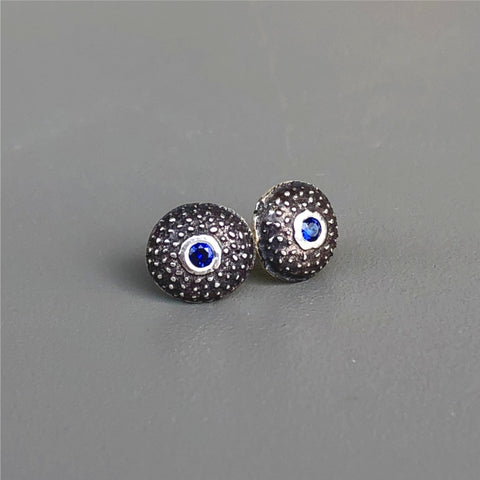 Handmade, unisex, sterling silver stud earrings, featuring beautiful etched patterns and set with deep blue Chatham sapphires. Jason Burton designs jewelry for women and men.